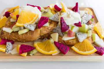 Close up of French toast with kiwi, apple, Dragon Fruit, orange and honey
