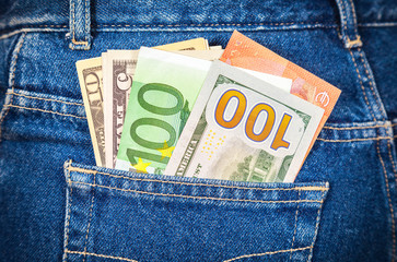 Different banknotes of Euro and american currency sticking out o