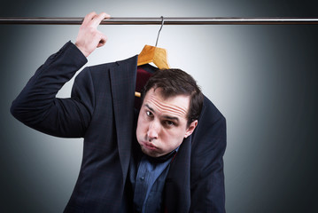 Man in suit hanging in the wardrobe. Embarrassing situation concept

