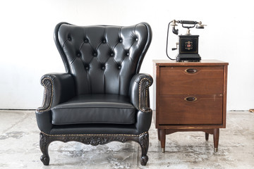vintage armchair and telephone on white wall.
