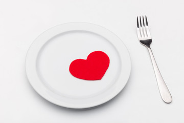 Fototapeta na wymiar Heart on a plate on white. Fork. The key to a girl's heart. Romantic dinner. Valentine's Day. red heart on a plate. love card.