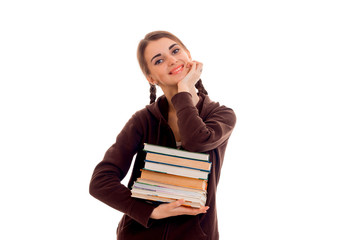 young beautiful student girl with a lot of books in her hands posing isolated on white background in studio