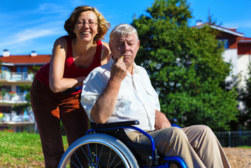 man on wheelchair with smiling young woman