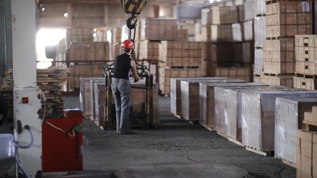 woman Factory worker in helmet transporting packing firebricks with workshop rail mounted gantry crane