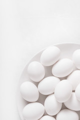 White eggs on a white plate on a white background. Eggs.  Easter photo concept. Copyspace