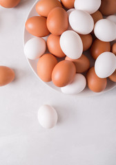 Brown and white eggs on a white plate on a white background. Eggs.  Easter photo concept. Copyspace