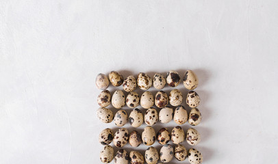 Quail eggs. Quail eggs in the shape of a square on a light background. Easter photo concept. Copyspace