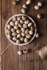 Quail eggs in a brown plate on a wooden table. Rustic Style. Eggs.  Easter photo concept. Copyspace