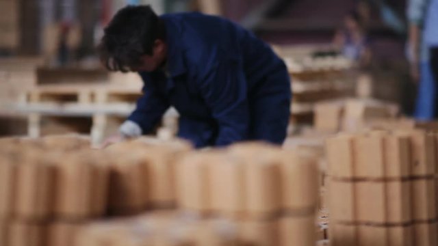 Work on the factory floor packs products. factory workers adds refractory bricks for further packaging.