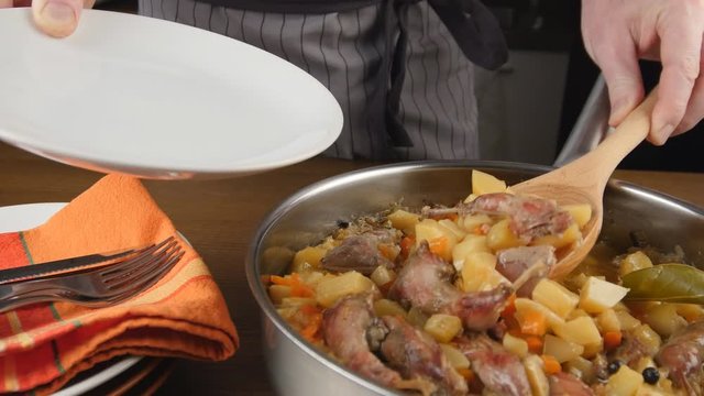 Putting quail legs and vegetables stew on a plate