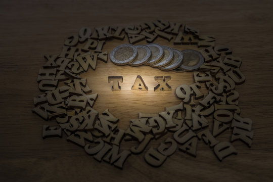 tax word made from plywood with coin stack ,business concept,lig