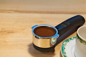 Porta filter with fresh ground coffee ready to brew in the espresso machine