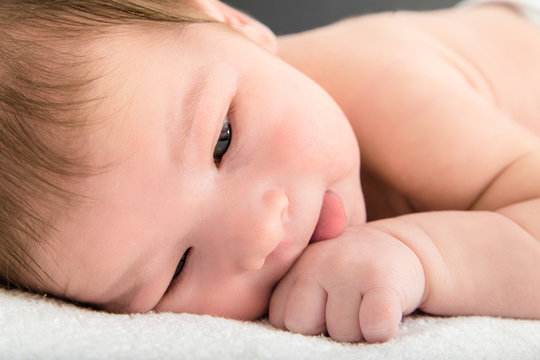 Close up picture of beautiful newborn baby resting on blanket