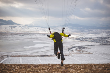 Man takes off with the speedglider from the mountain.