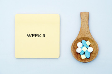 A medical pills in a wooden spatula with a medical note written on isolated white background....