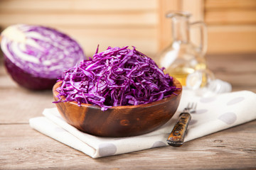 Red cabbage salad in a bowl on a table. Selective focus. Copy space.