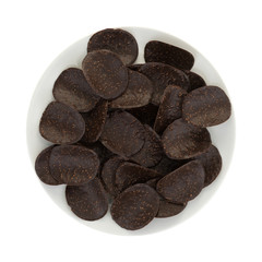 Chocolate covered rice crisps on a plate top view isolated on a white background.