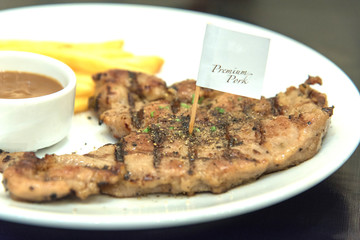 Grilled  pork steak, French fries and sauce