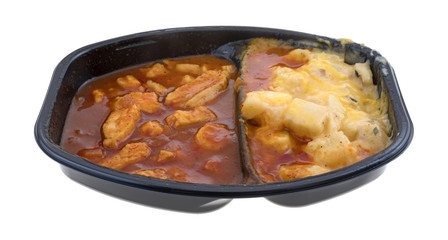 TV dinner of chicken chunks in barbecue sauce plus potatoes isolated on a white background.
