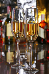 Celebration composition with two glasses white and red wine grapes on mirror table.