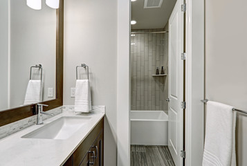 White and brown bathroom boasts a nook filled with double vanity