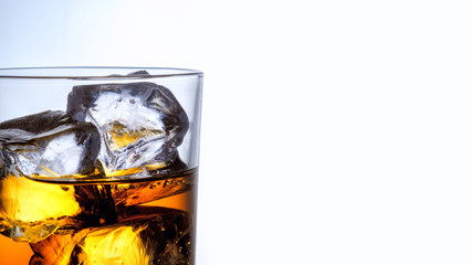 Whiskey glass with three ice cubes on white glass surface over white background