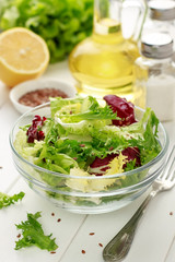 Healthy food for breakfast: fresh mixed salad with flax seeds on wooden background.