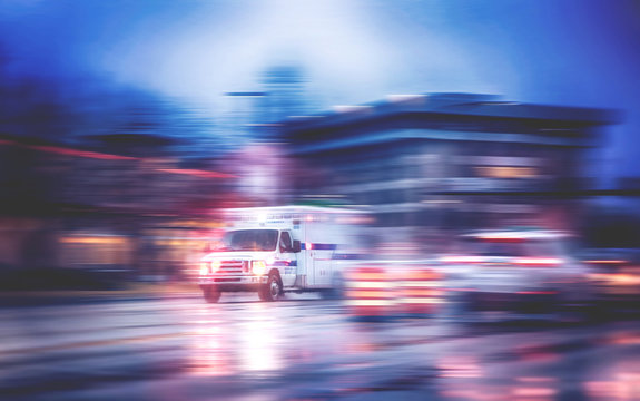 An Ambulance Racing Through The Rain On A Stormy Night With Motion Blur