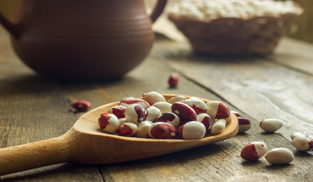 white beans on a table with wooden spoon