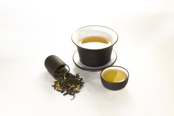 snuff cup with green, flower tea, gaiwan and a tea cup on a whit