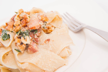 Pasta with cream sauce with bacon, mushrooms, walnuts, spinach