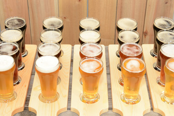 Beer flight sample showing variety of beer with paddle on rustic wooden table