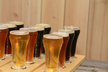 Beer flight sample showing variety of beer with paddle on rustic wooden table