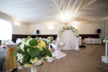 Wedding arch with flowers arranged in the restaurant for the wedding ceremony