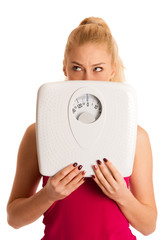 Worried woman standing on scale measuring weight