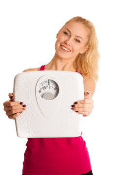 Happy young blond woman showing a scale as she has perfect shape