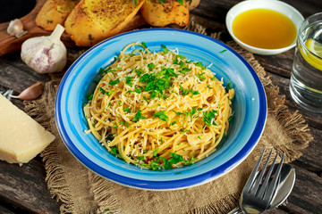 Vegetarian Italian Pasta Spaghetti Aglio E Olio with garlic bread, red chili flake, parsley, parmesan cheese and glas of water