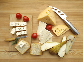 Cheese board of the three types of cheese. Brie, feta and Maasdam with pear and crackers