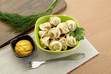 Russian dumplings - pelmeni, in green bowl