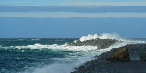 Crashing waves on breakwater in a stormy windy day.