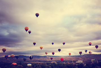 hot air balloons in the sky during sunrise toned with a retro vintage filter