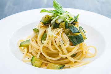 piatto di spaghetti con zucchine e foglie di menta 