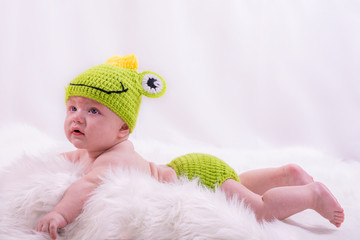 Adorable 6 month old baby boy in a knitted frog outfit