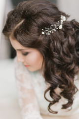 Portrait of attractive young woman with beautiful hairstyle and stylish hair accessory, rear view