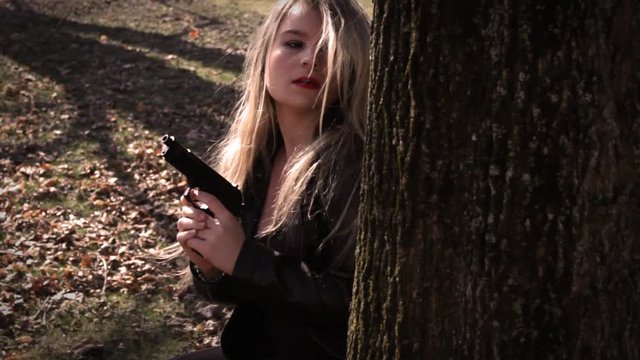 Female Secret Agent hides behind tree with gun   Action Movie Shots