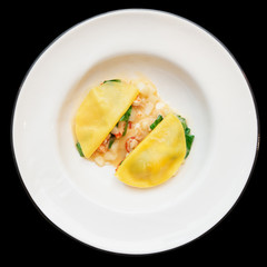 Ravioli-like dish with crayfish, apples and herbs isolated on bl