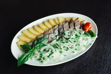 Pacific herring with onions on a white dish