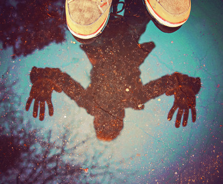  a person with a reflection is a puddle after the rain with tree