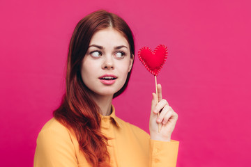 woman looks at tissue heart in hand, holiday of lovers