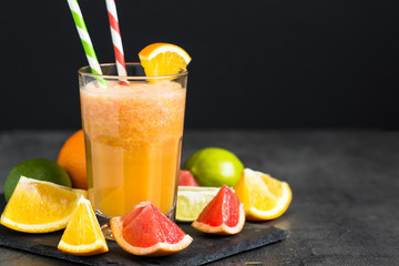 Fresh citrus smoothie juice at dark background.